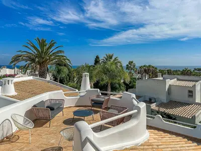 a patio with chairs and tables on a roof at Luxury Villa Heated Pool, walk to São Rafael Beach, Albufeira in Albufeira