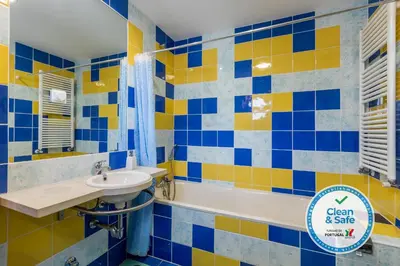 a blue and yellow bathroom with a sink and a tub at Marina de Albufeira Villa 8 in Albufeira