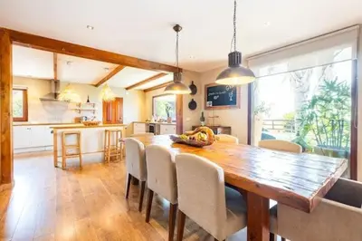 a kitchen and dining room with a wooden table and chairs at Villa Palm Retreat - Beautiful idyllic views in Boliqueime