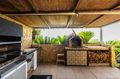 a kitchen with an outdoor kitchen with an outdoor oven at Villa Palm Retreat - Beautiful idyllic views in Boliqueime