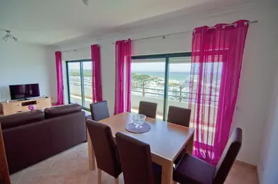 a living room with a couch and a large window at Dalia in Quarteira