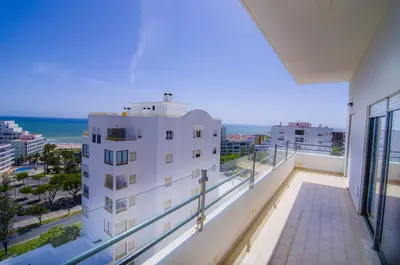 a balcony of a building with a view of the ocean at Dalia in Quarteira