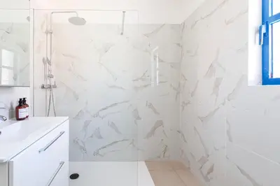a bathroom with white marble walls and a white tub at Centralgarve - Cosy&Central 1bdrm in Vilamoura - Pateos da Marina in Vilamoura