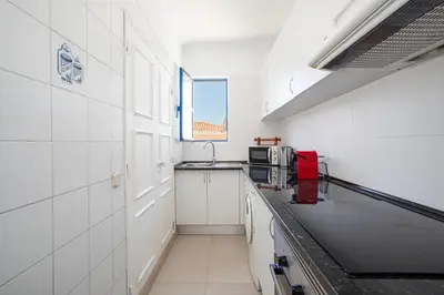 a white kitchen with a sink and a microwave at Centralgarve - Cosy&Central 1bdrm in Vilamoura - Pateos da Marina in Vilamoura