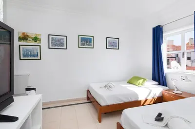 a white room with a bed and a television at Centralgarve - Cosy&Central 1bdrm in Vilamoura - Pateos da Marina in Vilamoura