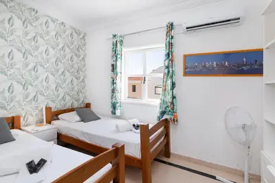 a room with two beds and a window at Centralgarve - Cosy&Central 1bdrm in Vilamoura - Pateos da Marina in Vilamoura