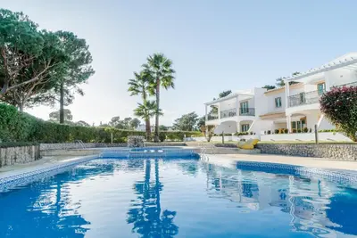 a swimming pool in front of a house at Falésia Cliff Apartment by The Portuguese Butler in Albufeira