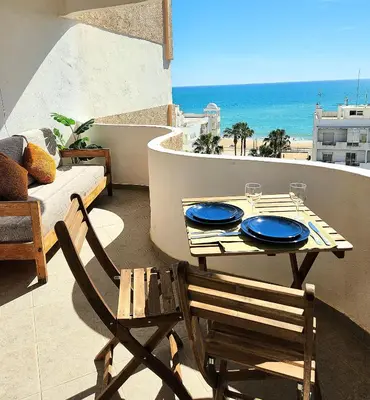 a table and chairs on a balcony with a view of the ocean at OceanView Side in Quarteira