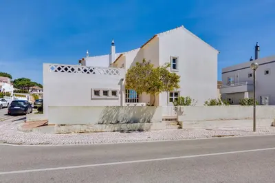 a white house on the side of a street at Villa Oliveiras de Vilamoura by The Portuguese Butler in Quarteira