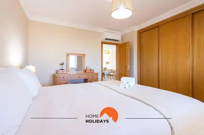 a bedroom with a bed with a home hudges sign on it at #130 Praia Village by Home Holidays in Vilamoura