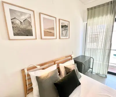 a bedroom with a bed with three pictures on the wall at Casa Diogo in Faro