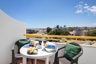 a table with a plate of food on a balcony at Apartment Montechoro in Albufeira