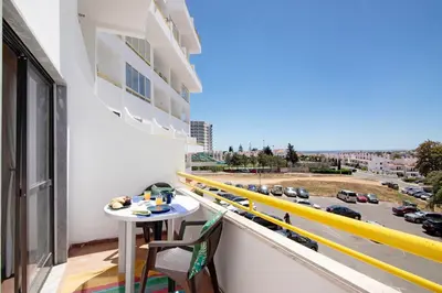 a balcony with a table and chairs and a view of a street at Apartment Montechoro in Albufeira