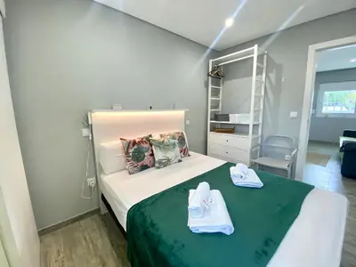a small bedroom with a bed with towels on it at Quarteira Stylish 2 by Homing in Quarteira