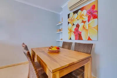 a dining room table with chairs and a bowl of fruit on it at Falésia Nature Villa by The Portuguese Butler in Albufeira