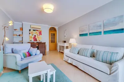 a living room with two couches and a table at Falésia Nature Villa by The Portuguese Butler in Albufeira