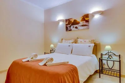 a bedroom with a bed with two towels on it at Falésia Nature Villa by The Portuguese Butler in Albufeira