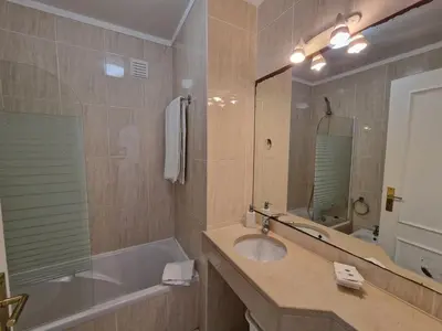 a bathroom with a sink and a tub and a mirror at Apartamentos Mar-Sol Villas in Vilamoura