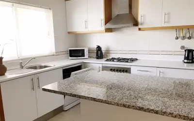 a kitchen with white cabinets and a counter top at Apartamentos Mar-Sol Villas in Vilamoura