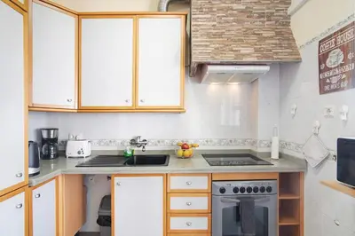 a small kitchen with a sink and a stove at Matinhos House in Faro