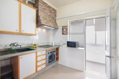 a kitchen with a sink and a microwave at Matinhos House in Faro