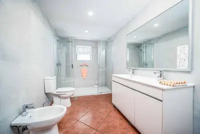 a white bathroom with a toilet and a sink at Villa Rato in Galé