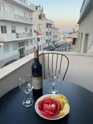 a table with a bottle of wine and a plate of food at Ocean View Getaway in Albufeira