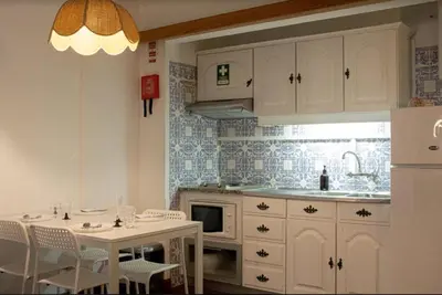 a kitchen with a sink and a table with chairs at Green 104 in Albufeira