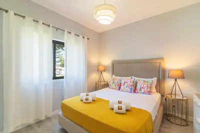 a bedroom with a bed with a yellow blanket at Vilamoura - MAGNÓLIA 512 - T1 in Vilamoura
