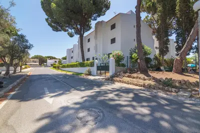 an empty street in front of a building with trees at Vilamoura - MAGNÓLIA 512 - T1 in Vilamoura