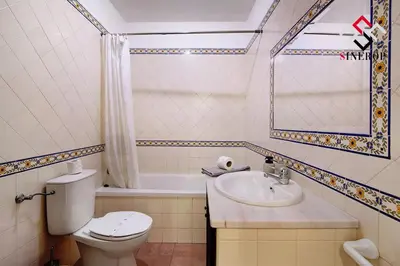 a bathroom with a toilet and a sink and a tub at Villa Tigonema in Albufeira