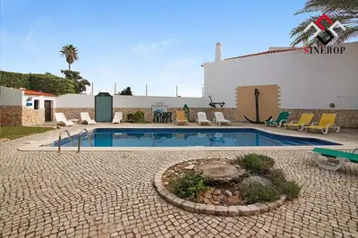 a swimming pool in front of a building at Villa Tigonema in Albufeira