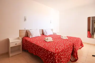 a bedroom with a bed with a red blanket at Apart 2 VelaMar - BY BEDZY in Albufeira