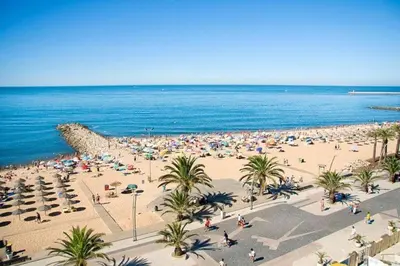 a beach with a lot of people and the ocean at Quarteira CONDESTÁVEL T3 in Quarteira