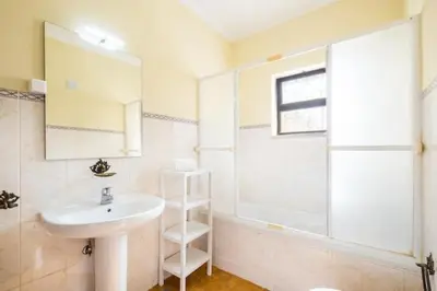 a bathroom with a sink and a shower and a window at Villa Camila - Ideal location ten-min walk to Albufeira Marina in Albufeira