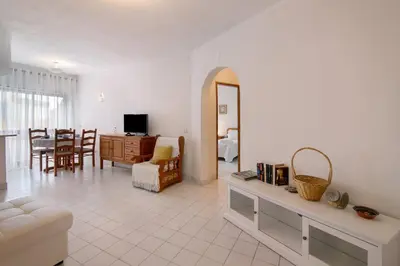 a living room with a couch and a dining room at Apartamento T1 Antonio Henriques in Albufeira