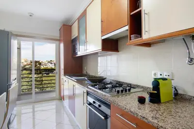 a kitchen with a stove top oven next to a window at T2 Tubio in Albufeira