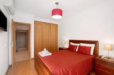 a bedroom with a red bed with a red blanket at T2 Tubio in Albufeira