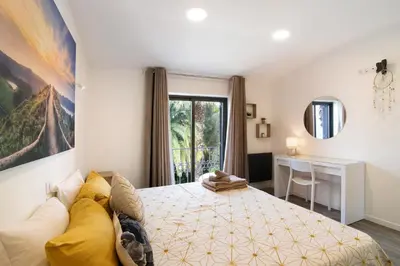 a bedroom with a bed and a desk and a window at Flat 2 Bedrooms Cunha in Albufeira