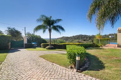 a brick pathway with a palm tree and a palm tree at Casa no Campo com vista mar in Loulé