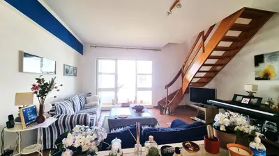 a living room with a blue couch and a piano at Praia da Galé, 250m da Praia e Piscina in Galé