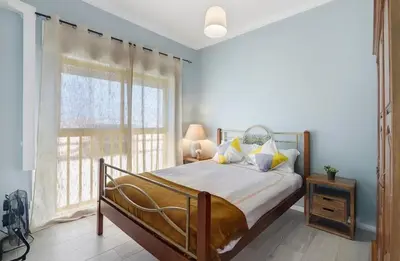 a bedroom with a bed with yellow and white pillows at Apartamento SUN7SET in Quarteira