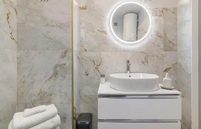 a bathroom with a white sink and a mirror at Apartamento SUN7SET in Quarteira