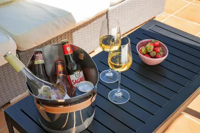 a table with two glasses of wine and a bowl of fruit at Villa Simone in Almancil