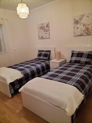 a bedroom with two beds and a couch at T2 Infante Moderno Wi-Fi Garagem 50 M Praia in Quarteira