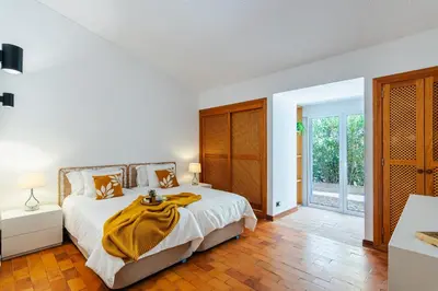 a bedroom with a bed with a yellow blanket on it at Villa Sea, Sun and Golf in Vilamoura in Quarteira