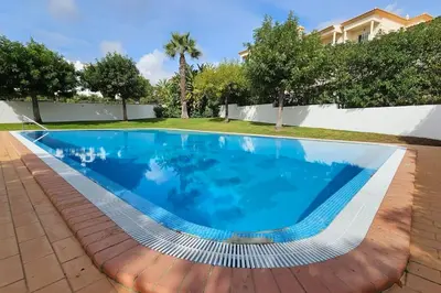 a swimming pool with blue water in a yard at D'Água Brisa beachside apartment in Albufeira