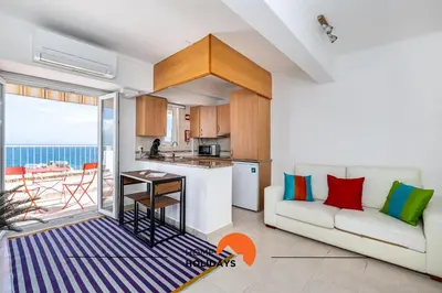 a living room with a couch and a kitchen at #195 Rossio Mar by Home Holidays in Albufeira