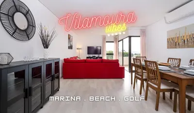 a living room with a red couch and a table at Vilamoura - Spacious with Swimming Pool & View in Vilamoura