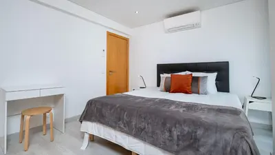a bedroom with a large bed and a desk at Vilamoura - Spacious with Swimming Pool & View in Vilamoura